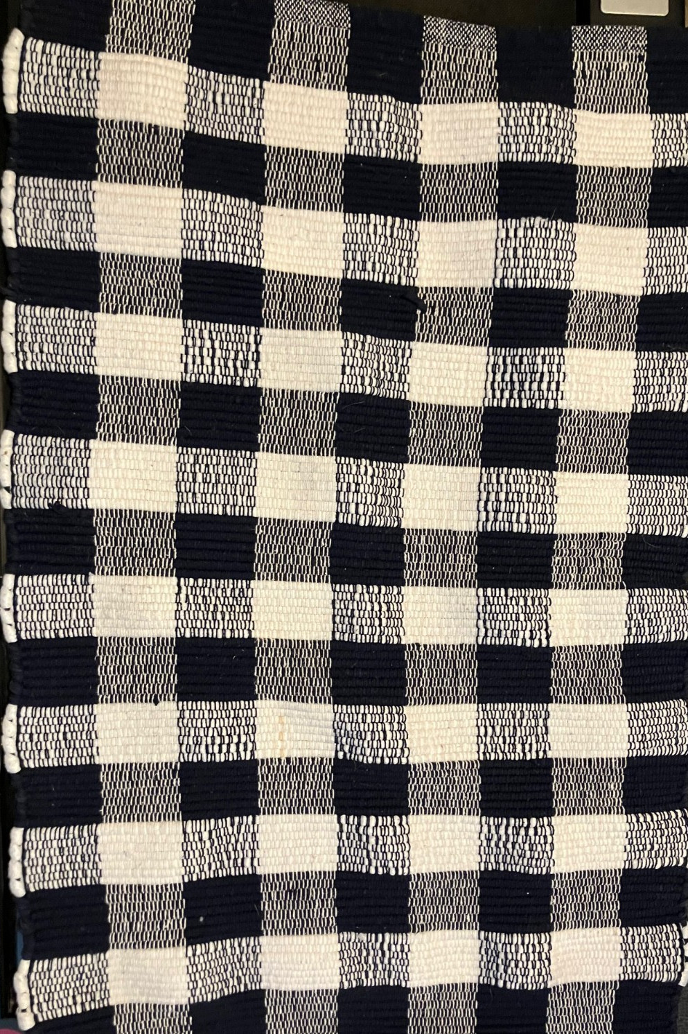 Blue & White Outdoor Layering Rug features a classic gingham checkered pattern