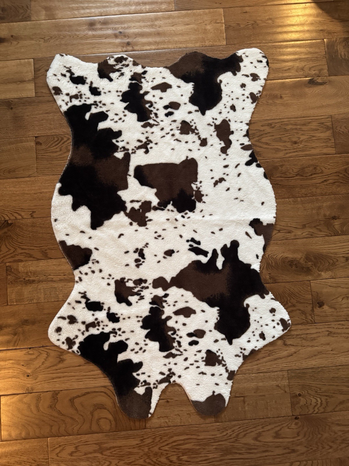 faux cowhide rug designed with a brown, white, and black animal print.